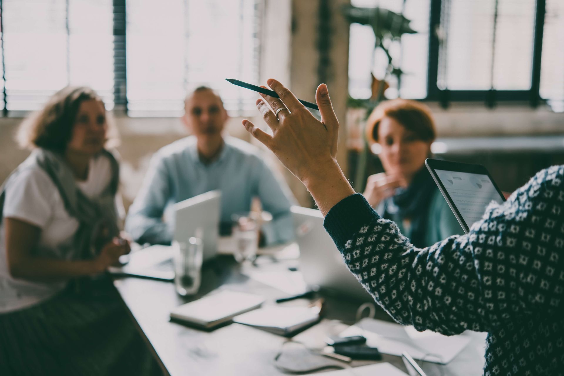 Meeting mit 4 Leuten an einem Schreibtisch