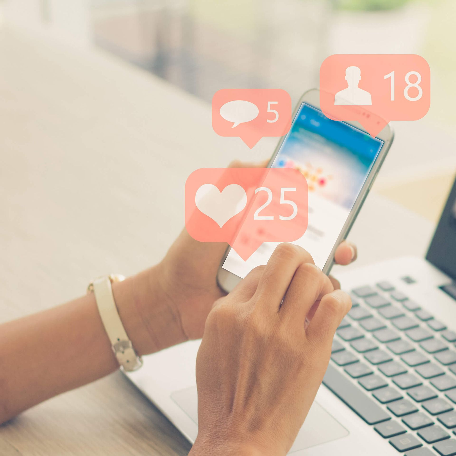 Hand hält Handy, darüber schweben Like-Icons